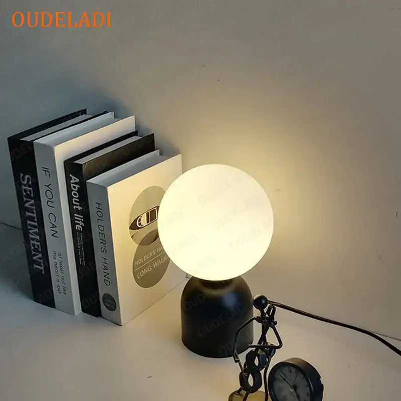 Sleek decorbites black iron table lamp with matte finish and glowing white glass ball shade for home decor lighting