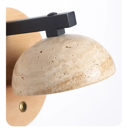 Beige stone dome wall lamp with a black iron led wall light arm for bedside use by DecorBites™
