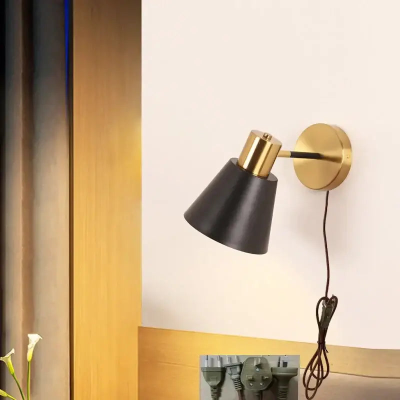 Decorbites black iron wall sconce with black conical shade brass accents and matching circular base for modern lighting