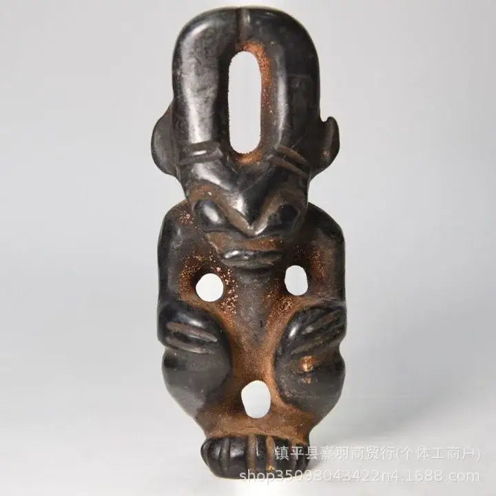 Dark brown carved stone pendant with three white inlays featuring a stylized face in the decorbites black iron meteorite sun collection