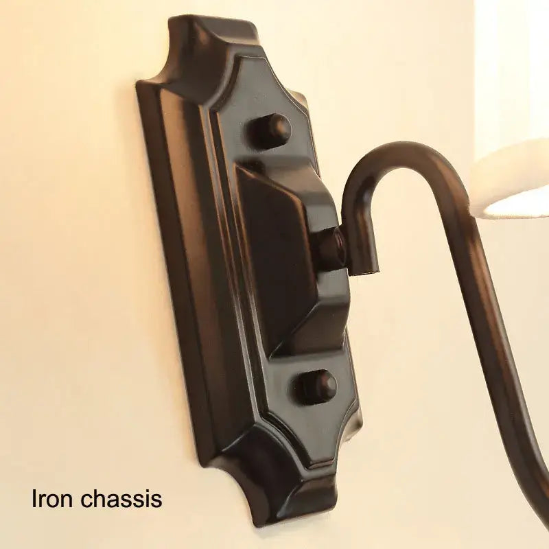 Dark bronze black iron wall lamp with ornate rectangular chassis and curved arm from DecorBites black iron series