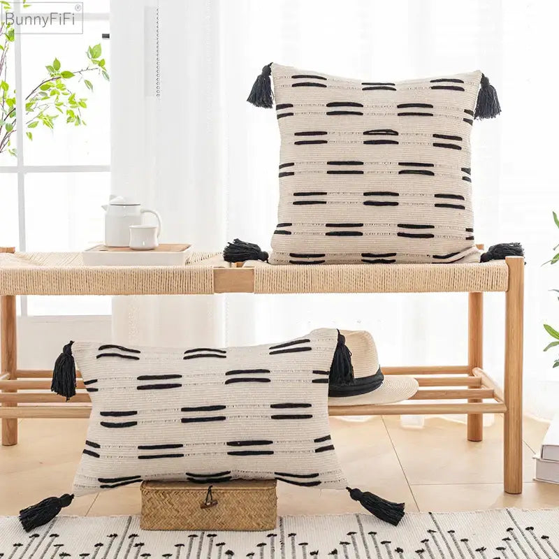 Cream-colored woven cushion cover with black horizontal tassels and textured stripes for living room decorbites black ivory decor