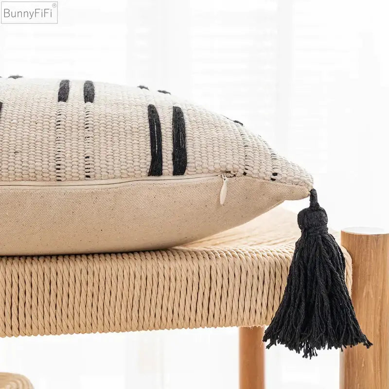 Beige woven cushion cover with black vertical stripes and tassel accent for living room decorbites black ivory style