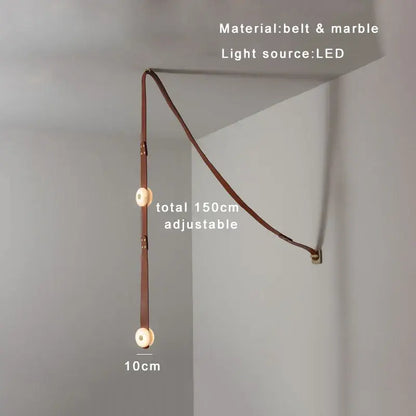 A sleek 150cm decorbites black leather wall sconce with adjustable circular lights in marble and leather for dining rooms
