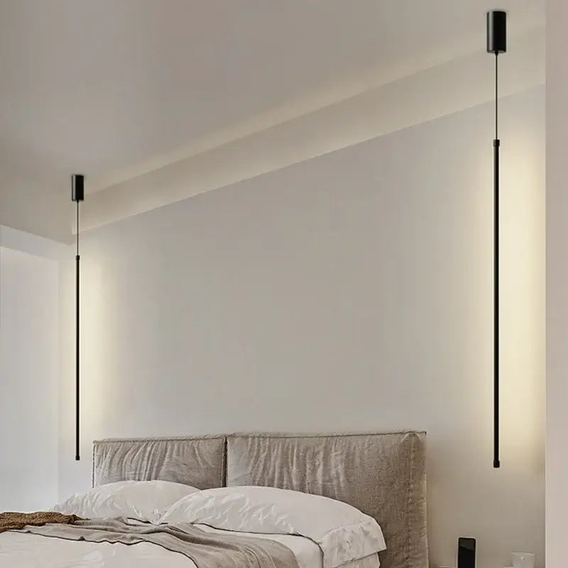 Two sleek black pendant lights with slim rods and warm glow featured in DecorBites black led chandelier for dining room