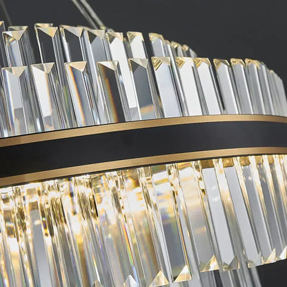A decorbites black led crystal chandelier with clear faceted prisms and a black and gold band for luxury dining rooms