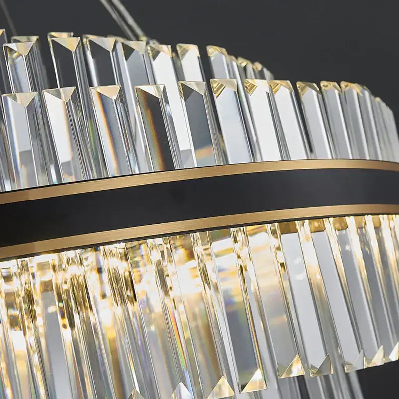 A decorbites black led crystal chandelier with clear faceted prisms and a black and gold band for luxury dining rooms