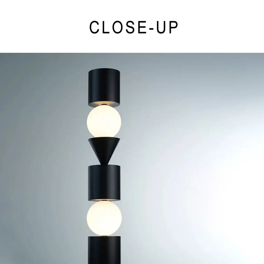 Decorbites black led floor lamp features black cylindrical and conical fixtures with two glowing white spherical bulbs