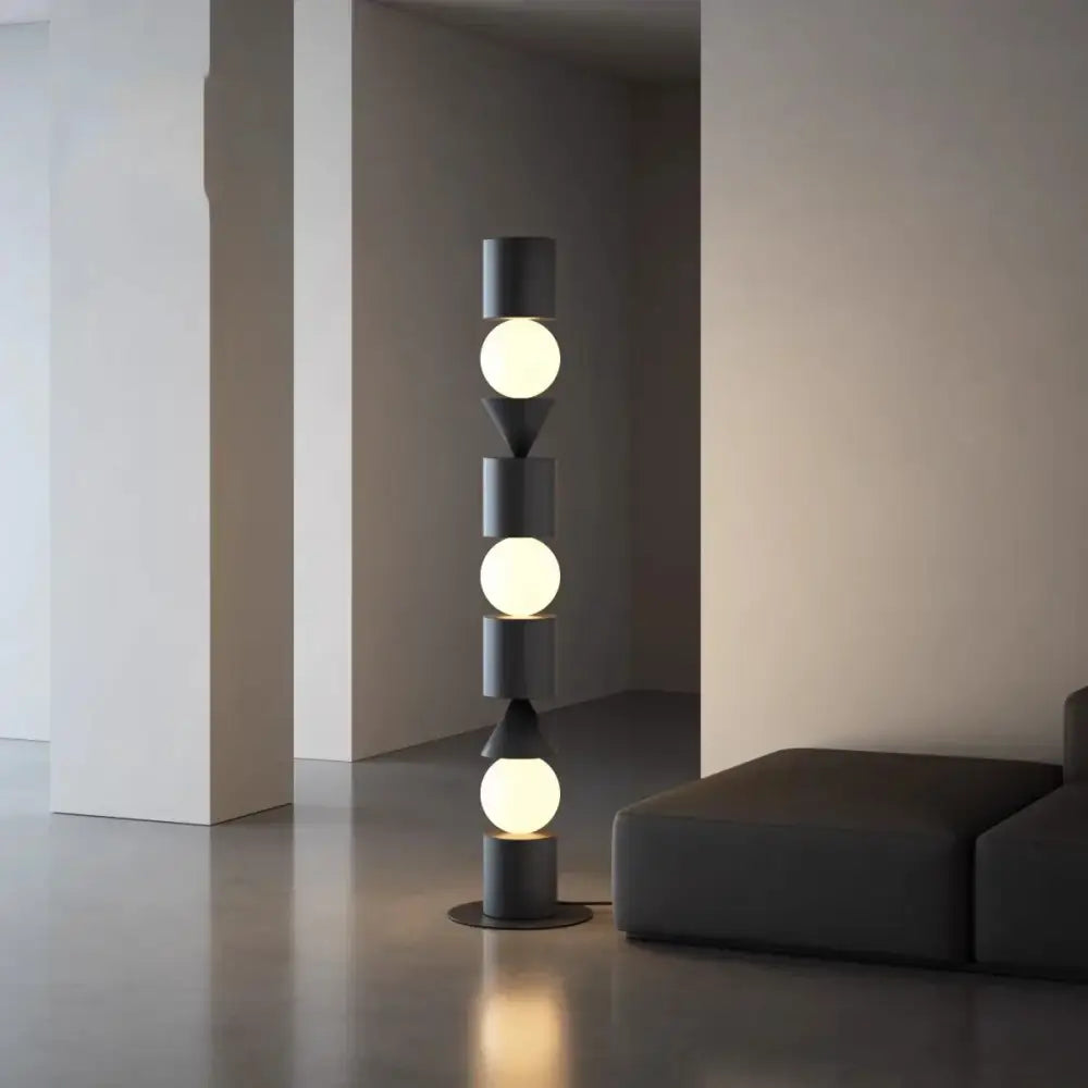 Modern black cylindrical floor lamp with three glowing spherical bulbs and geometric accents by DecorBites black led floor lamp