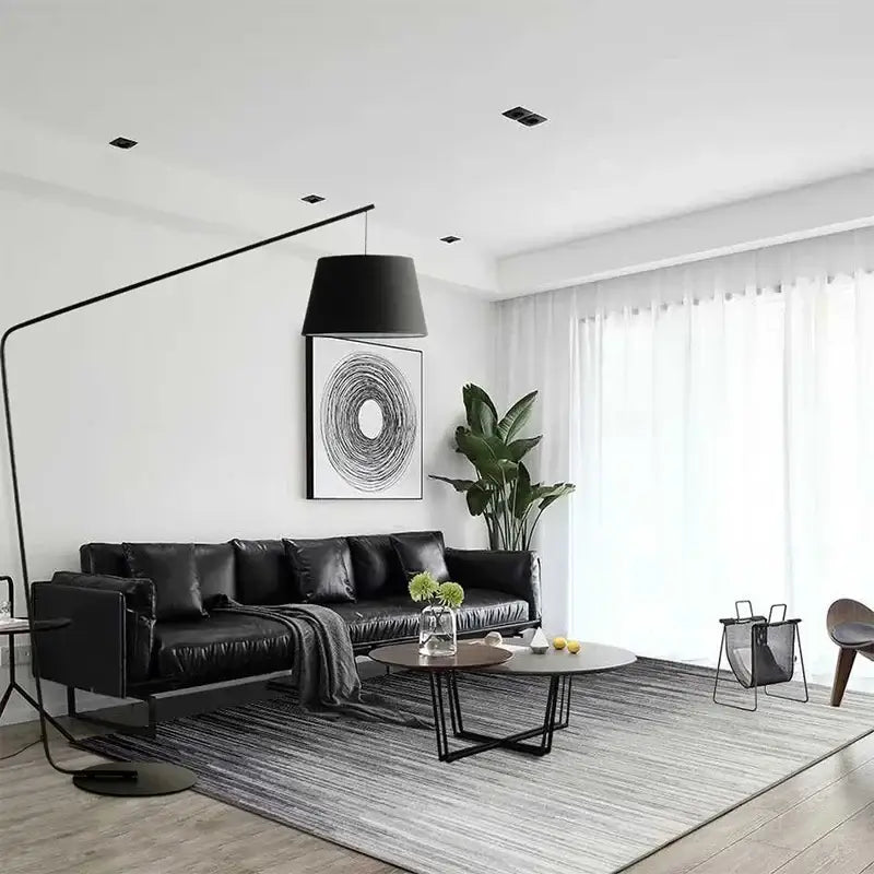Black leather sectional sofa with modern design and plush cushions beside a sleek black decorbites led floor lamp