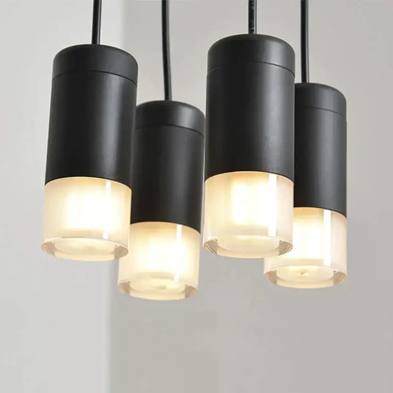 Decorbites black led linear chandelier with black cylindrical pendants and frosted glass bases emitting warm glow