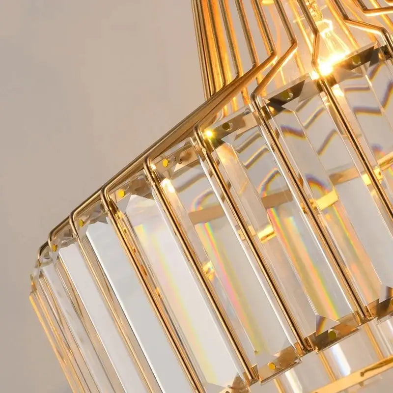 Gold-toned pendant chandelier with clear faceted crystal prisms in a geometric pattern for modern Nordic design