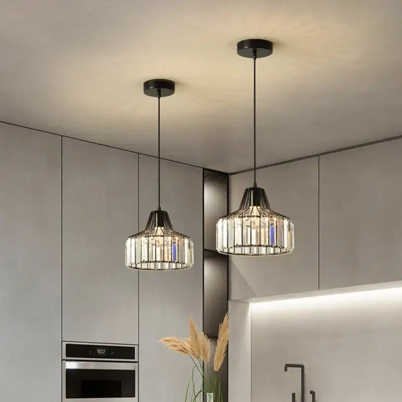 Two modern decorbites black led pendant chandeliers with black metal frames and clear glass rods for kitchen dining room