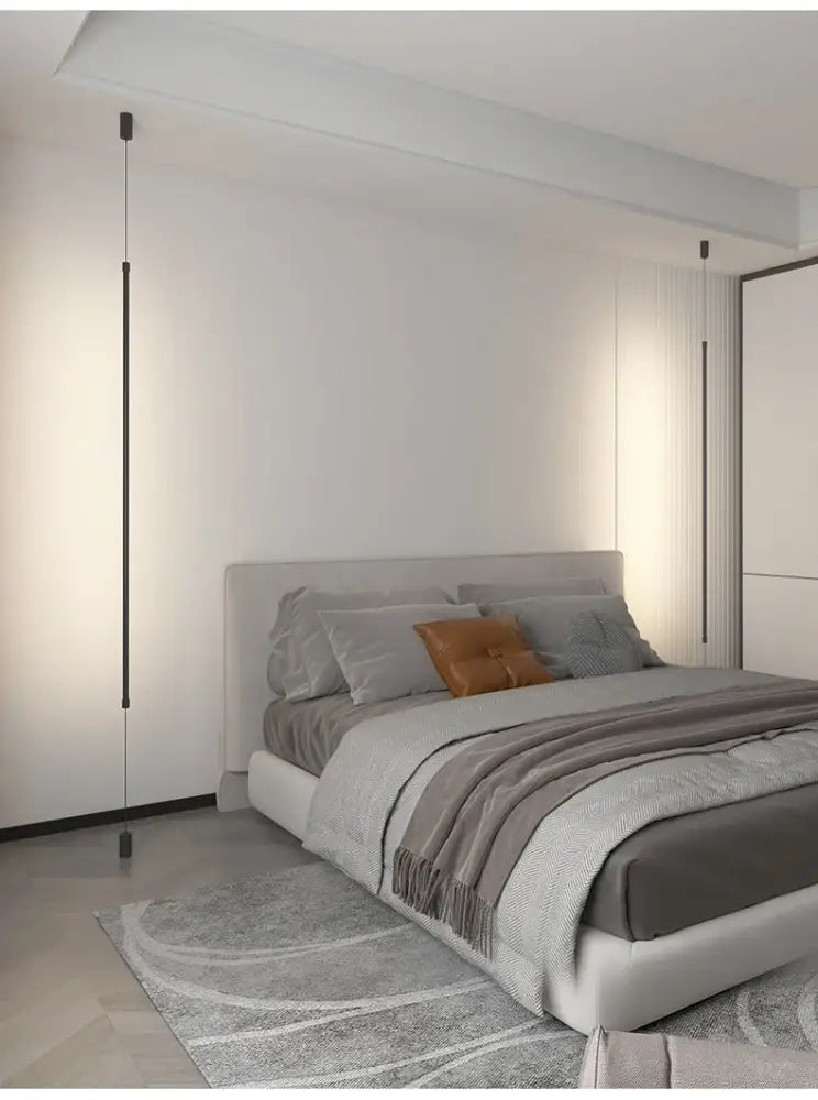 Modern minimalist bed with gray bedding and orange pillow under DecorBites™ black led pendant chandeliers for nordic decor