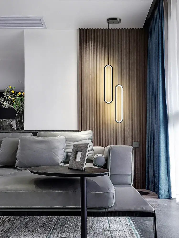 Modern minimalist decorbites black led pendant light with sleek oval shapes and warm ambient glow for elegant bedrooms