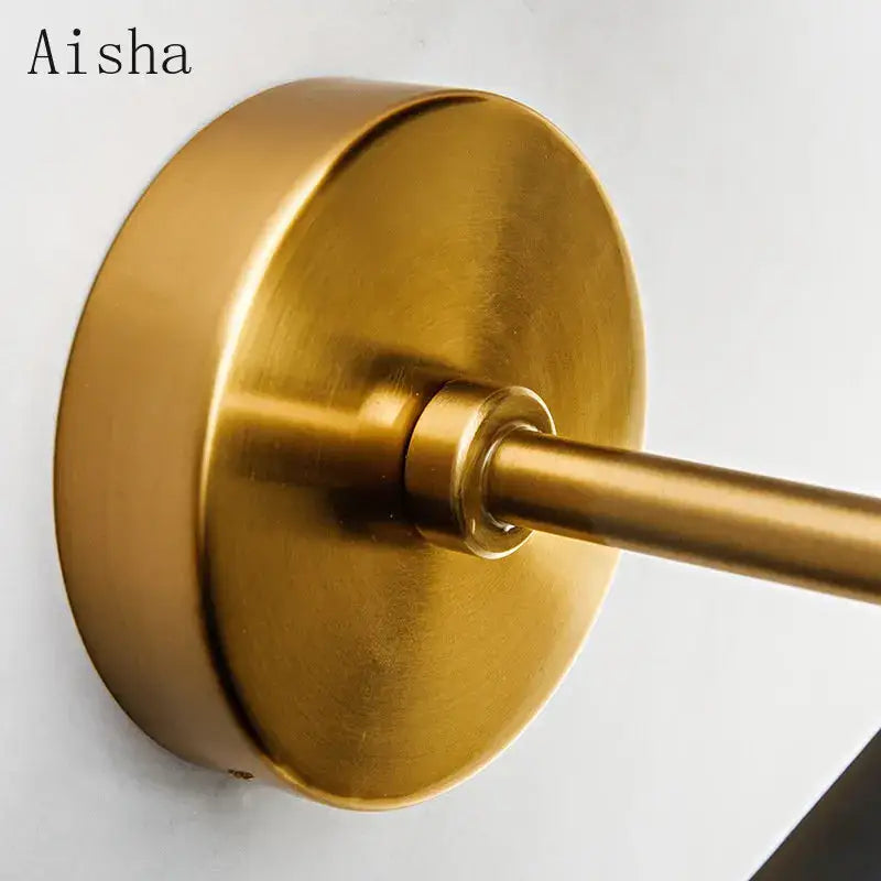 Brass-finished wall-mounted towel rack with circular base and cylindrical rod paired with decorbites black led wall lamp