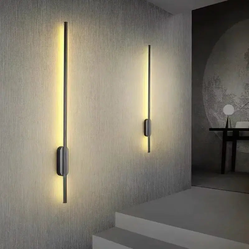 Two sleek decorbites black led wall lights with slender metallic rods and warm yellow light for modern indoor décor