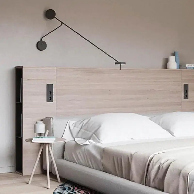 Modern decorbites black led wall reading light with sleek black metal arms and circular shades mounted above bed
