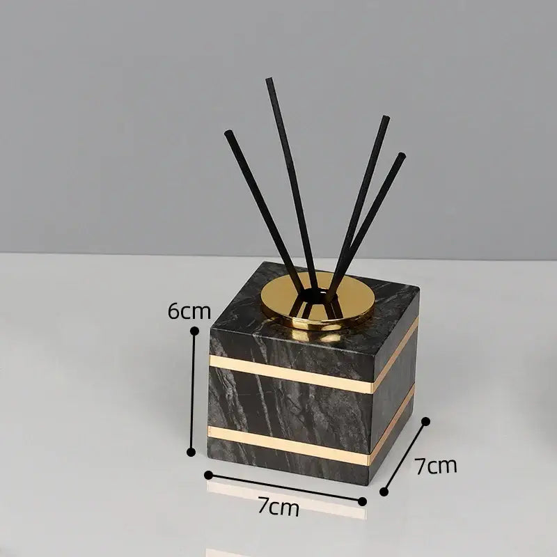 Decorbites black marble square diffuser with gold metallic accents and black reed sticks for black marble bathroom use