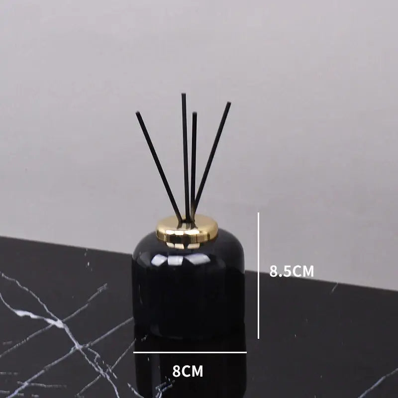 Black ceramic reed diffuser with gold-toned metal cap and five black reeds from decorbites black marquina bathroom set