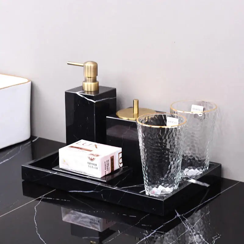 Black marquina marble bathroom set by decorbites featuring a tray with gold soap dispenser and textured glass tumblers