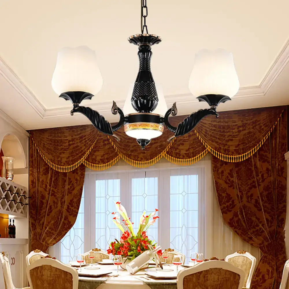 Decorbites black metal chandelier with three frosted glass shades and gold accents in ornate floral design