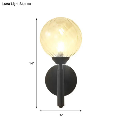 Modern black wall sconce with a warm amber spherical lamp and clear textured glass for bedroom lighting