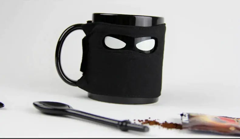 Decorbites black ninja mug with soft fabric sleeve featuring eye cutouts and sword stirrer kitchen novelty cup