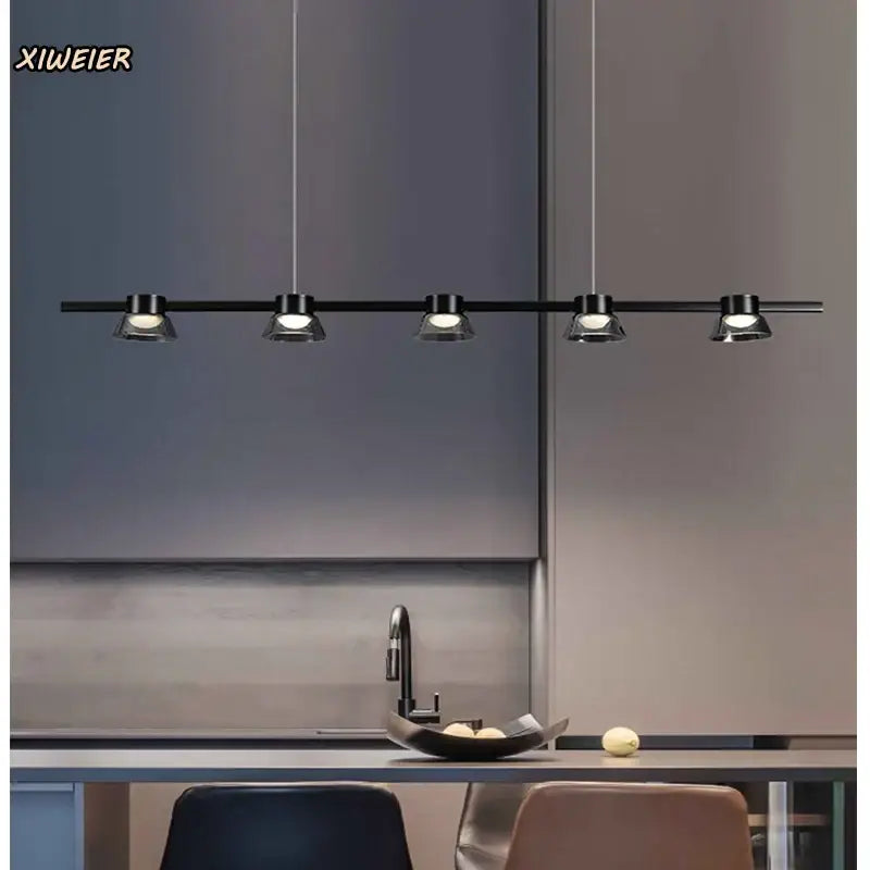 Decorbites black strip chandelier with five sleek black pendant light fixtures suspended above kitchen counter