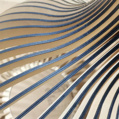 Blue and beige striped leather strips forming a wave pattern beside decorbites black wood cage chandelier spherical lamp