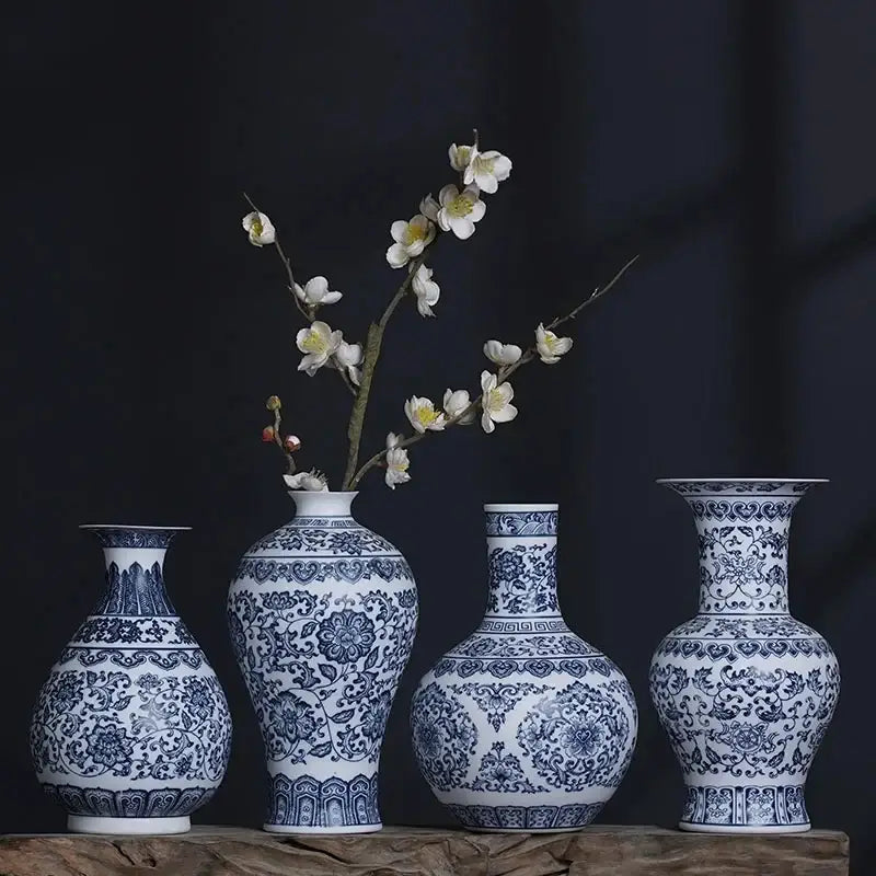 Four blue and white ceramic vases with intricate floral patterns arranged on a wooden surface for elegant home decor