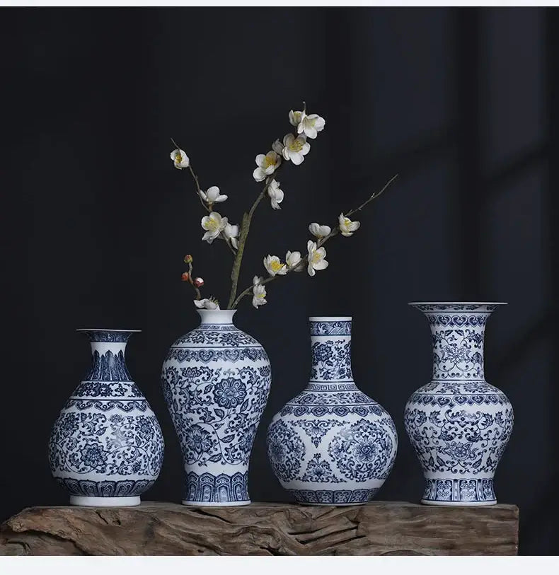 Four blue and white ceramic vases with intricate floral patterns displayed on a wooden surface for elegant home decor