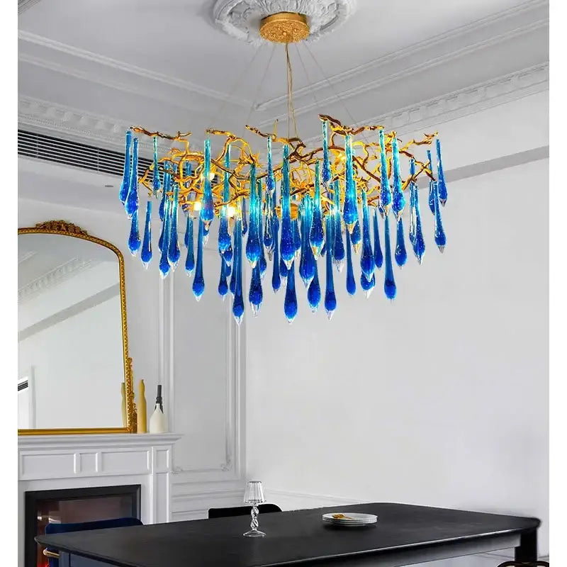 Decorbites blue crystal chandelier with vibrant blue glass and gold branching arms for dining room lighting