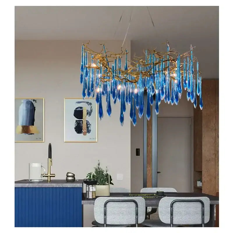 A decorbites blue crystal chandelier with gold branching arms and teardrop crystals for dining room lighting