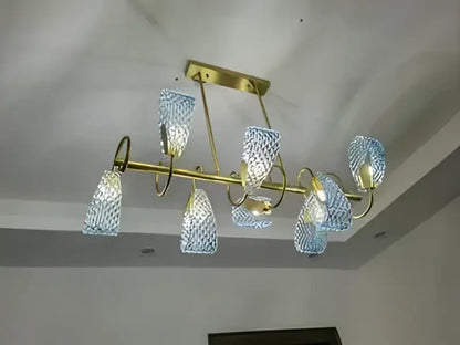 A modern chandelier with a brass frame featuring multiple blue glass led pendant lamps for designer lighting