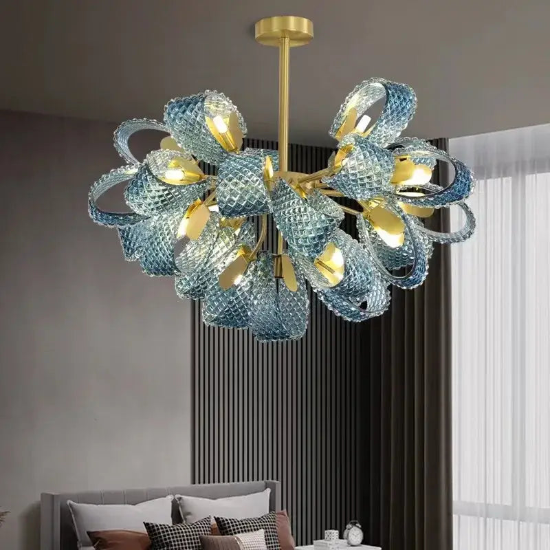 A modern decorbites™ pendant lamp with intricate blue glass led petals and gold-toned metal accents