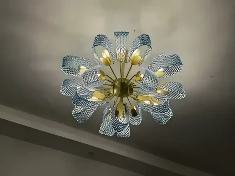 DecorBites™ blue glass led pendant lamps feature a delicate light blue glass chandelier with golden hub and petal arms