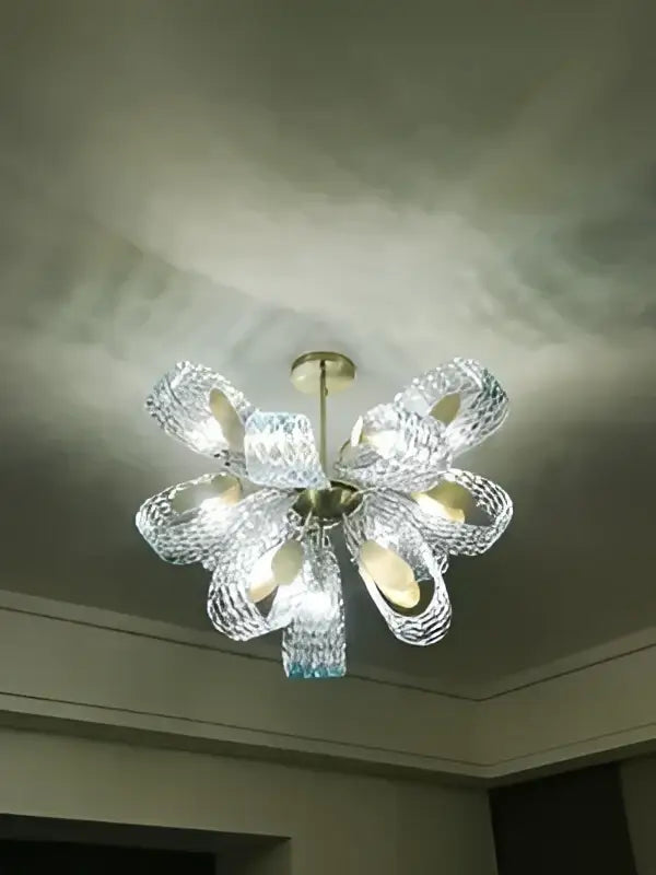 A crystal chandelier with a metallic center and clear glass arms showcasing elegant floral design in modern pendant lamps