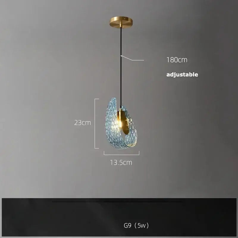 A delicate blue glass LED pendant lamp with a textured finish hangs from an adjustable brass ceiling mount