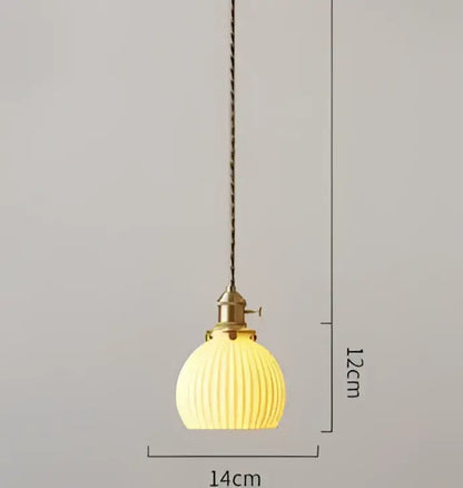 A warm yellow ribbed glass pendant light with brass fixture and chain, complementing decorbites blue glass pendant style