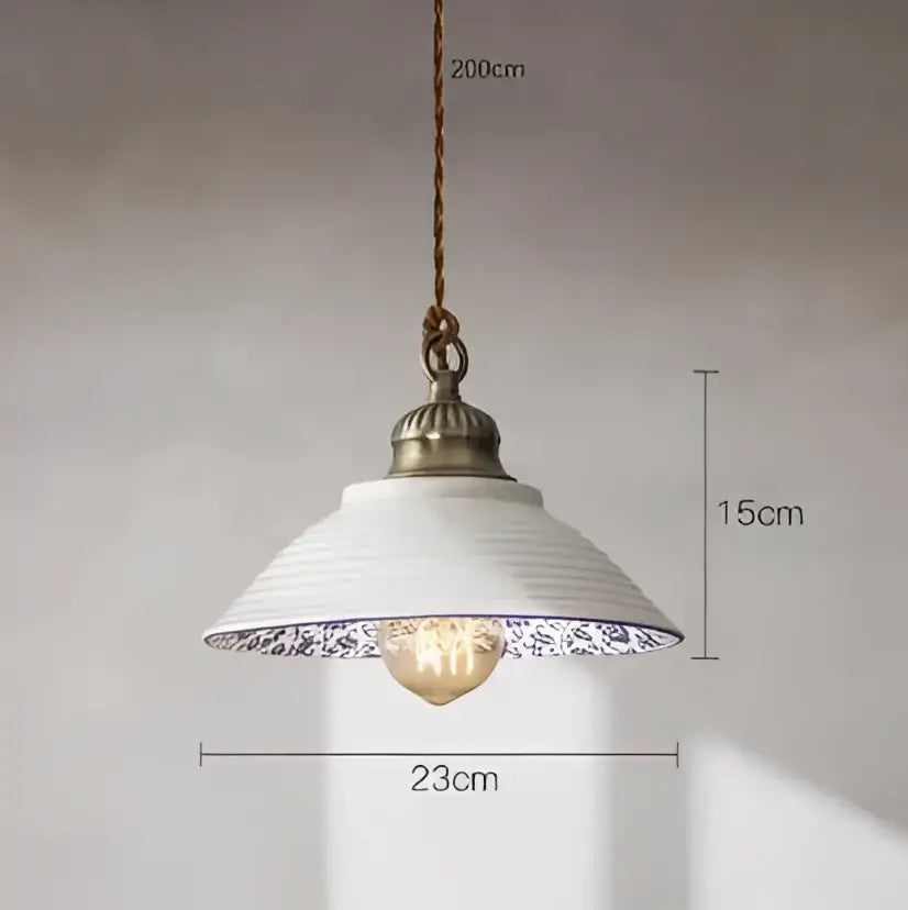 White ceramic pendant light with blue floral rim and antique brass fixture complementing decorbites blue glass pendant