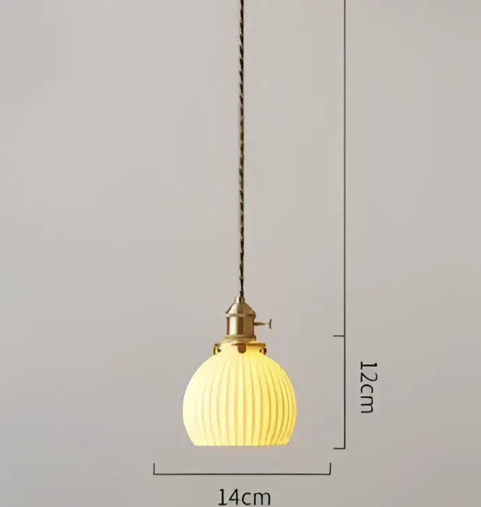 A warm yellow ribbed glass pendant light with brass fixture and chain contrasting decorbites blue glass pendant lights