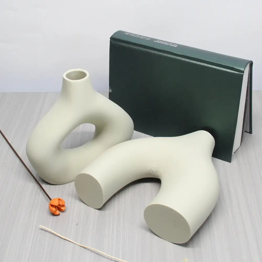 Cream-colored ceramic vase set with smooth abstract organic shapes and hollow centers for bohemian home decor