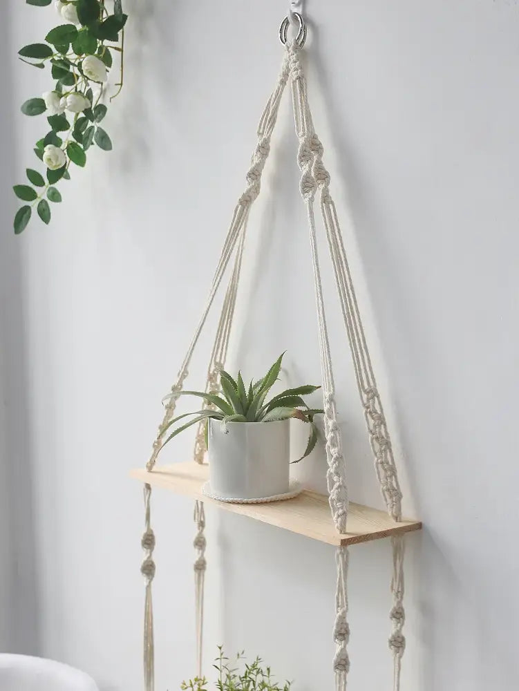 DecorBites™ boho macrame wall shelf with light wood slat and cream cords holding white ceramic pot for home decor