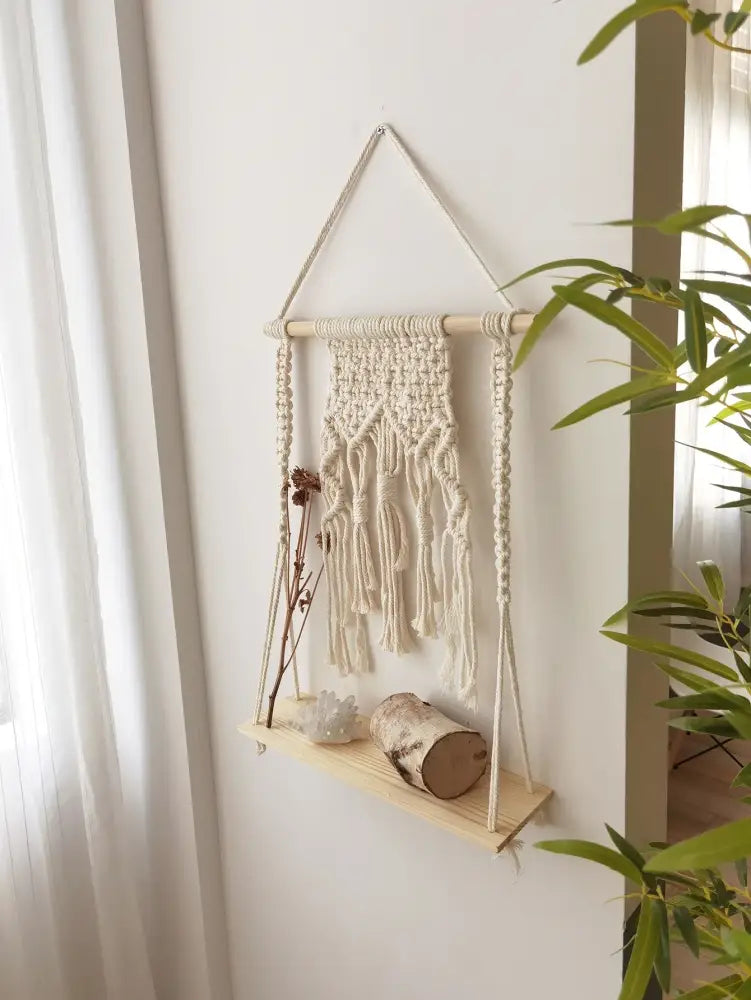 Cream-colored DecorBites™ boho macrame hanging shelf with wooden wall shelf and tassels for home decor
