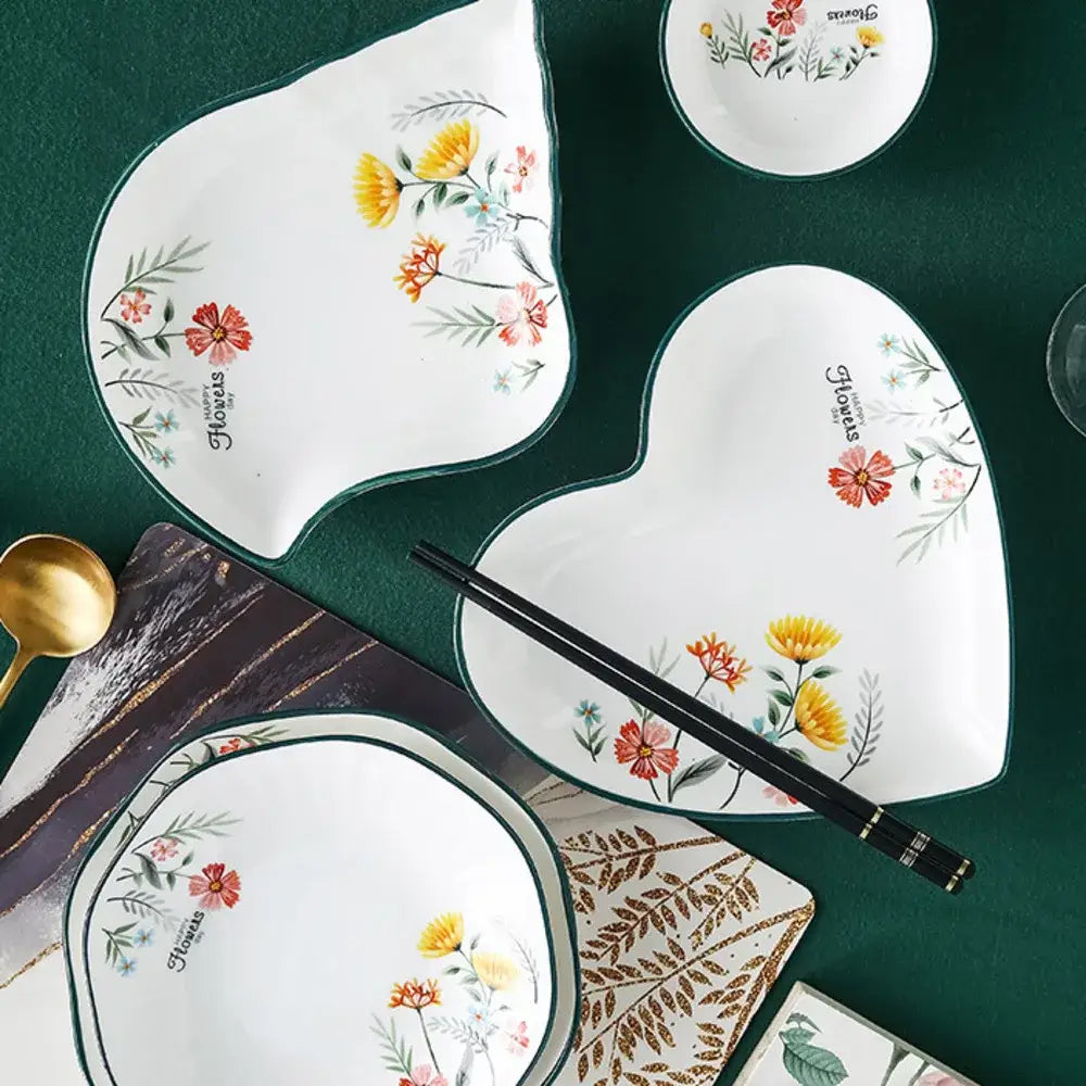 White ceramic heart-shaped rice noodles bowl and dinner plate set with colorful floral designs and green rims by DecorBites bone china