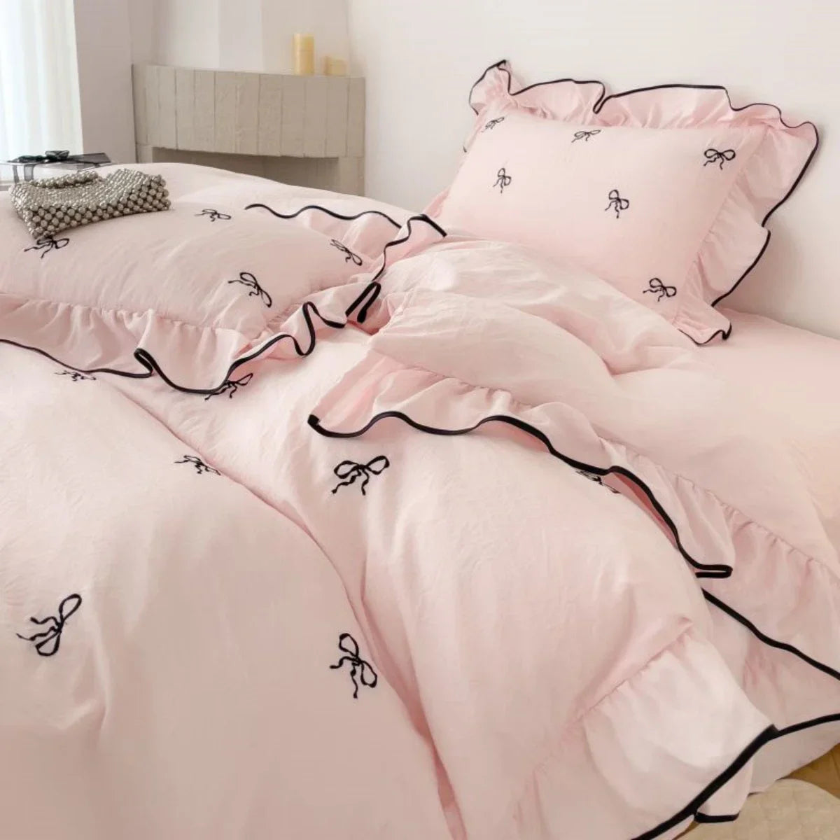 Pink ruffled bedding set with black bow embroidery and contrasting trim from decorbites embroidery bedding set