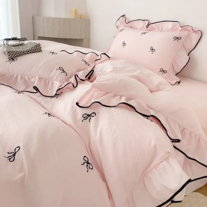 Pink ruffled bedding set with black bow embroidery and contrasting trim from decorbites embroidery bedding set