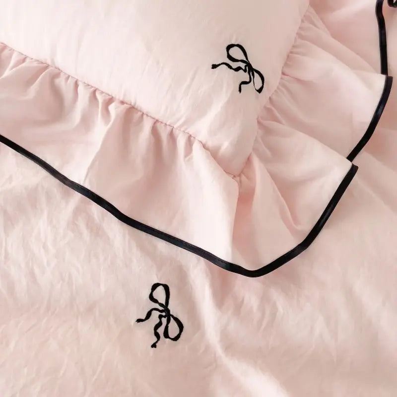 Pink ruffled pillow sham with black bow embroidery and contrasting piping from decorbites bow embroidery bedding set