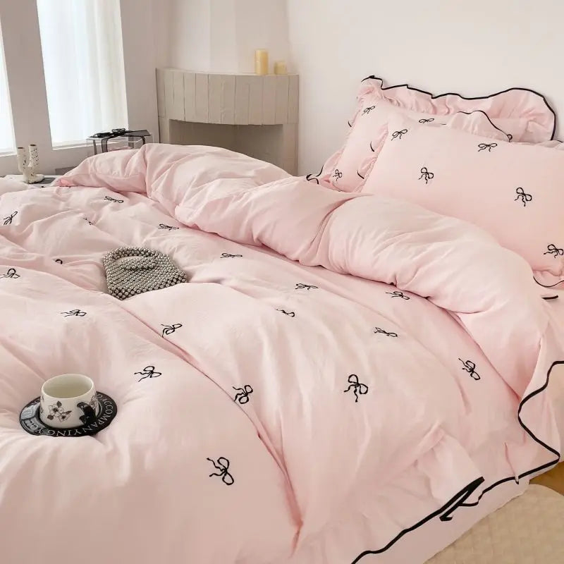 Pink decorbites™ bow embroidery bedding set with ruffles featuring black bow embroidery and ruffled edges